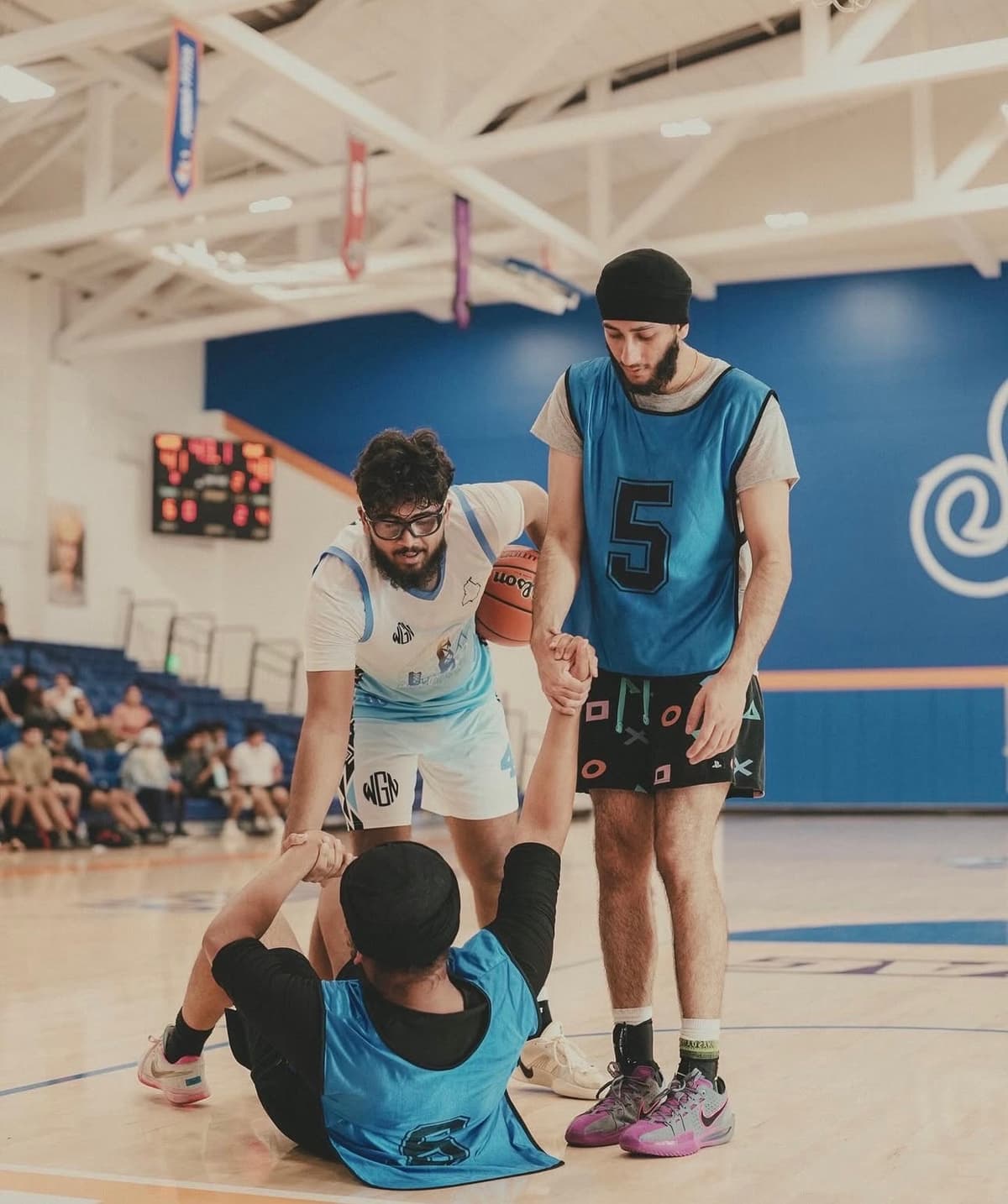 Basketball teammates helping each other up - Basketball is Family